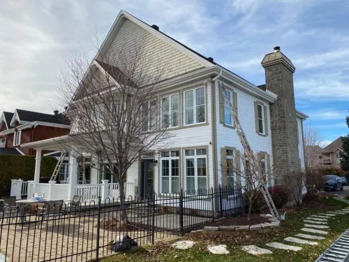 Peinture extérieure d'une maison à revêtement blanc