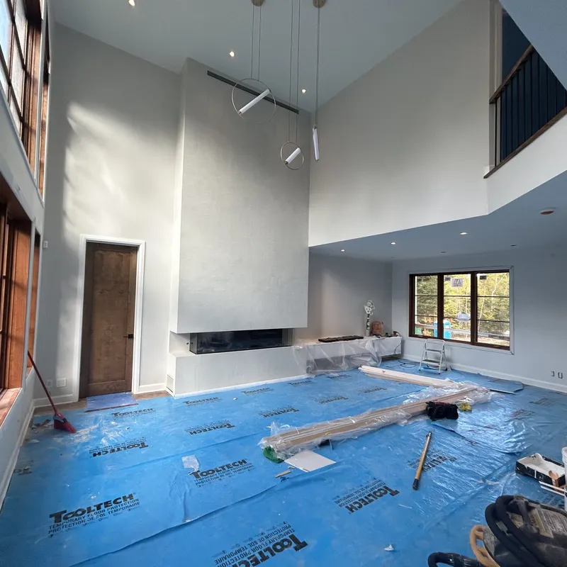 Salon à plafond cathédrale pendant les travaux de peinture, planchers protégés
